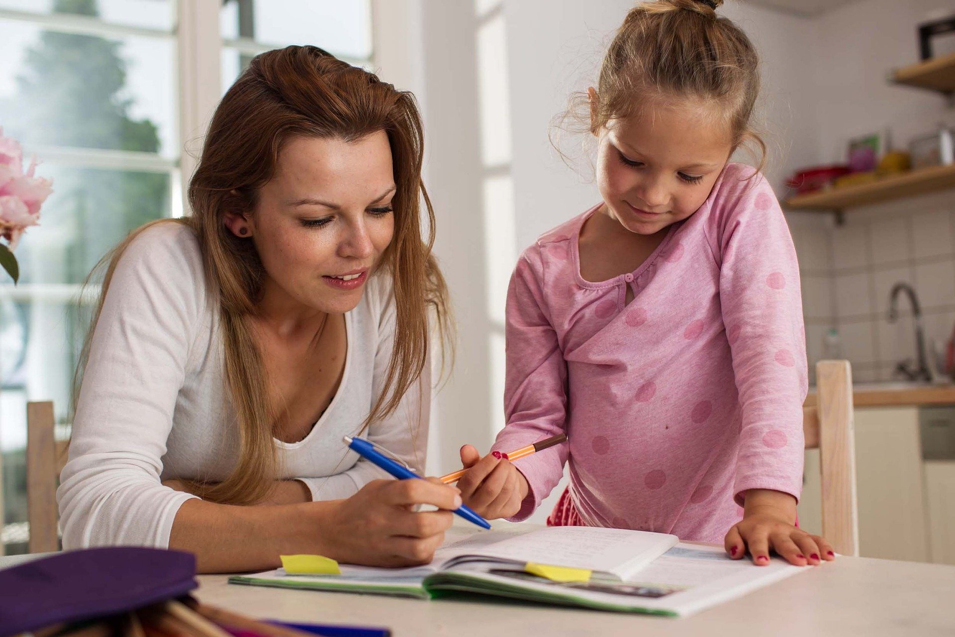 Mom and daughter doing workbook together